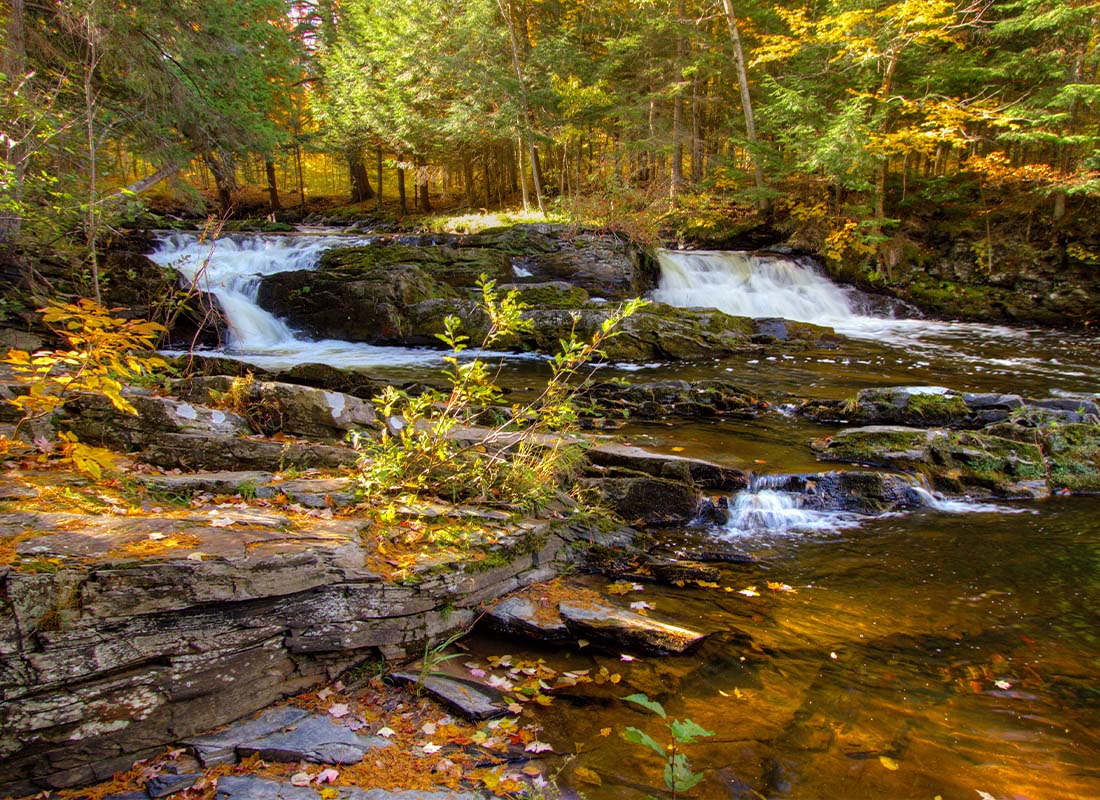 About Our Agency - Double Waterfall With Fall Foliage on the Falls River in the Small Town of L’Anse in the Upper Peninsula of Michigan