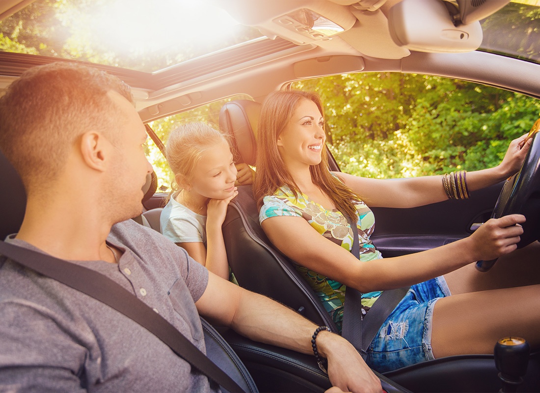 Personal Insurance - Happy Young Family Driving in a Car Together